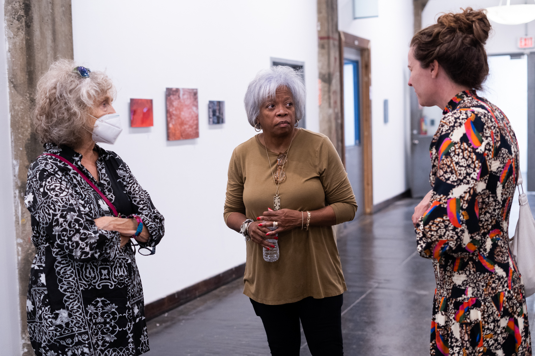 Image Description: Karen D. Bailey (in middle) talks with two others at the opening reception of "A Closer Look".